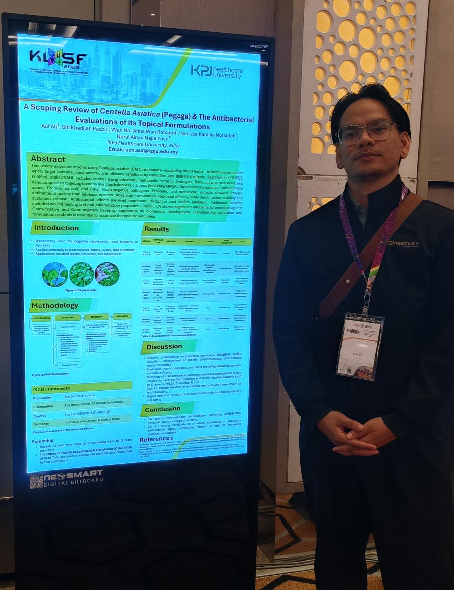 Auf Ali beside his digital poster on Centella asiatica at KLSF 2025